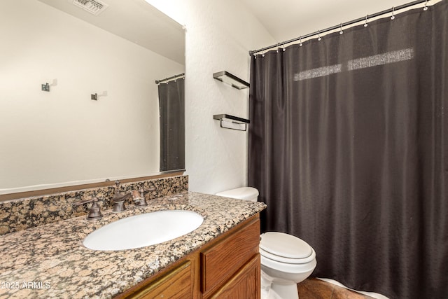 bathroom featuring visible vents, vanity, and toilet