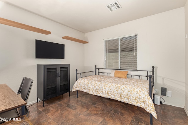 bedroom with baseboards, visible vents, and stone finish flooring