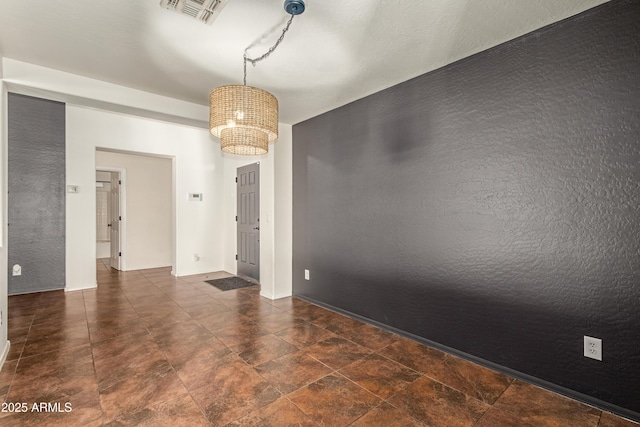 spare room with an inviting chandelier and visible vents