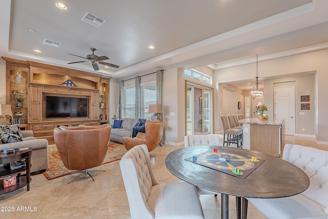 dining room with a raised ceiling and ceiling fan