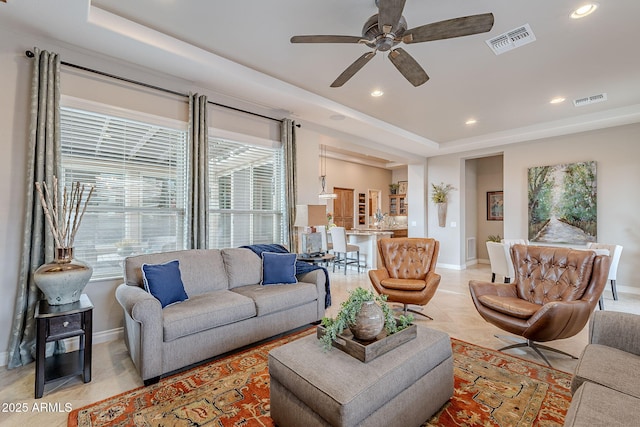 tiled living room featuring a raised ceiling and ceiling fan