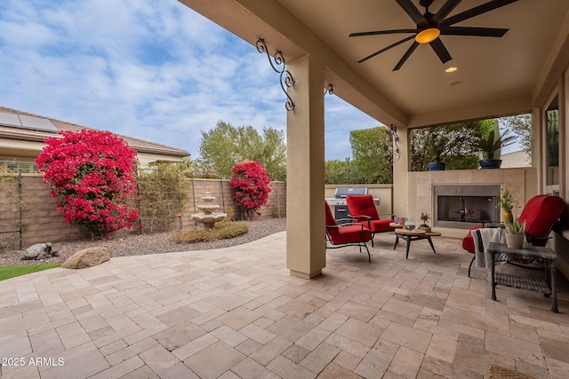 view of patio / terrace featuring ceiling fan and an outdoor living space with a fireplace