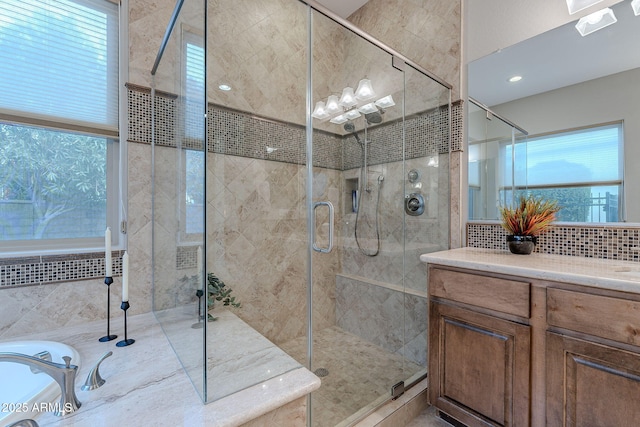 bathroom featuring vanity, decorative backsplash, and walk in shower