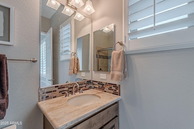 bathroom with vanity, decorative backsplash, and a wealth of natural light