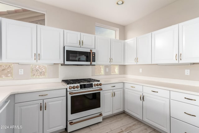 kitchen featuring white cabinetry, light hardwood / wood-style flooring, and high end stove