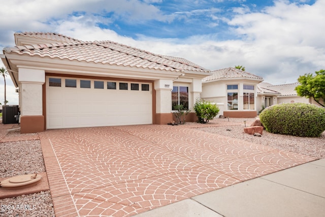 mediterranean / spanish-style house featuring central AC and a garage