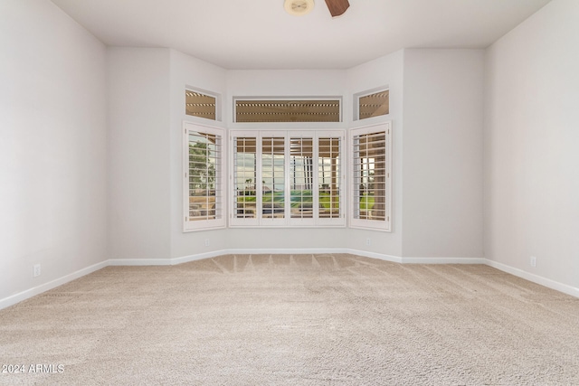 spare room featuring ceiling fan and carpet