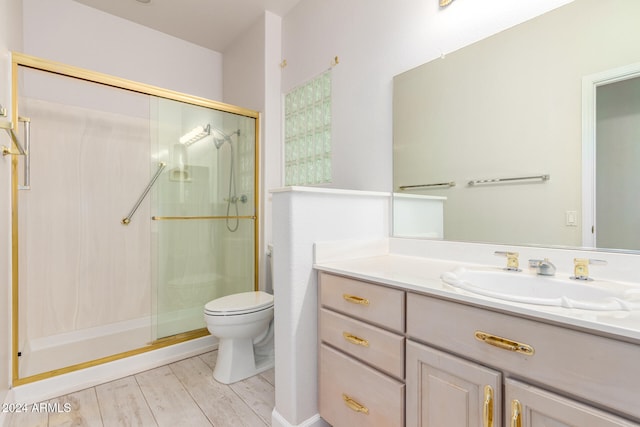 bathroom featuring vanity, wood-type flooring, toilet, and walk in shower