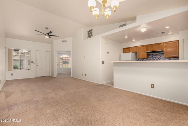 8140 N 107th Ave Unit 287, Peoria, AZ 85345 - unfurnished living room with a chandelier, light colored carpet, vaulted ceiling, a ceiling fan, and baseboards