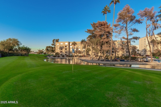 surrounding community featuring a yard, golf course view, and a water view