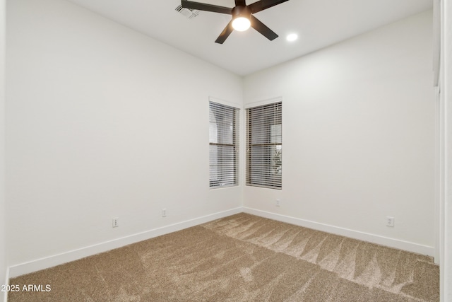 empty room with baseboards, visible vents, carpet floors, and ceiling fan