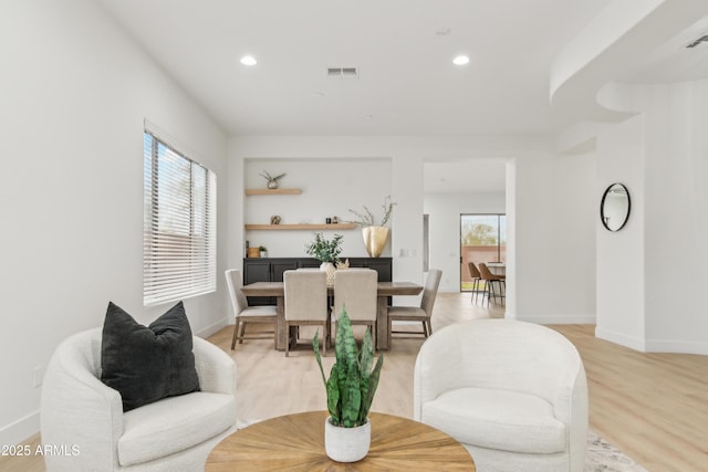 living room featuring recessed lighting, visible vents, plenty of natural light, and light wood-style flooring