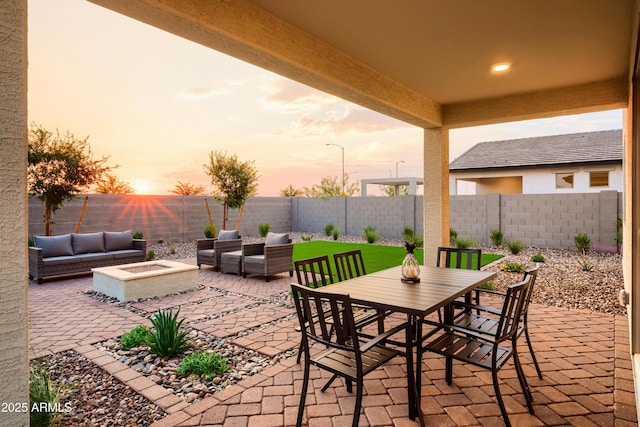 patio terrace at dusk featuring an outdoor living space with a fire pit