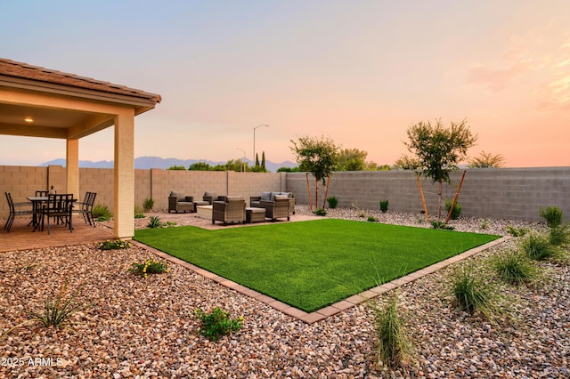 yard at dusk with outdoor lounge area and a patio