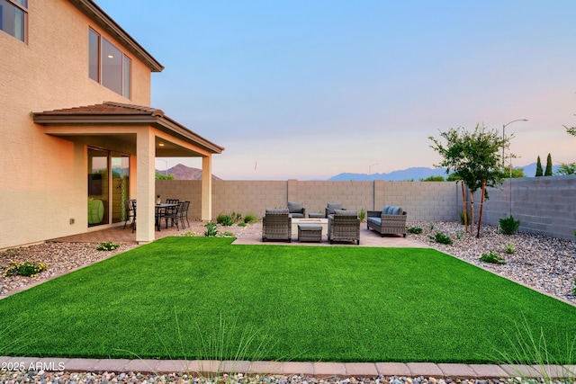 yard at dusk with a patio area and an outdoor living space