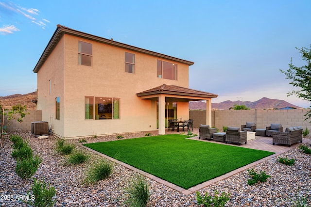 rear view of property featuring an outdoor hangout area, central air condition unit, a patio area, a mountain view, and a yard