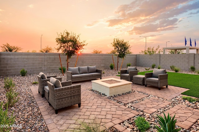 patio terrace at dusk with an outdoor living space with a fire pit