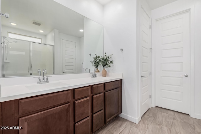 bathroom with vanity and a shower with door