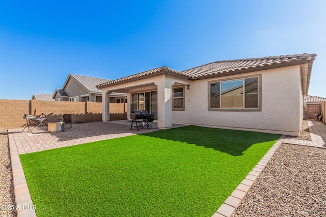 back of property with a patio area and a lawn