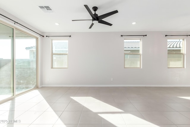 tiled spare room featuring ceiling fan and plenty of natural light