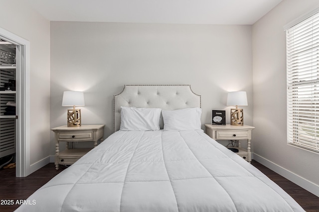 bedroom with dark wood-type flooring and multiple windows