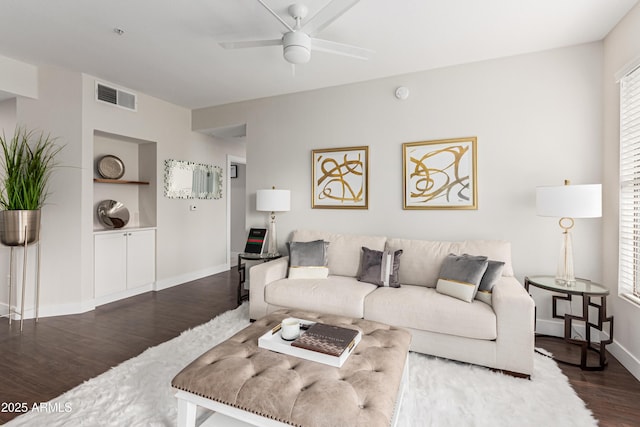 living room featuring ceiling fan, plenty of natural light, dark hardwood / wood-style flooring, and built in features