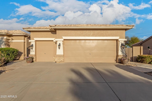 view of front of home with a tile roof, stucco siding, an attached garage, and concrete driveway