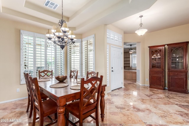 dining space with a tray ceiling, a wealth of natural light, visible vents, and a notable chandelier