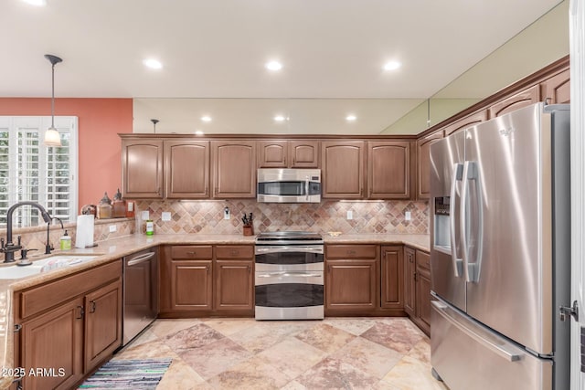 kitchen with backsplash, hanging light fixtures, a sink, and stainless steel appliances
