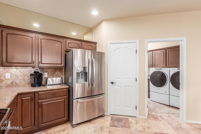 kitchen with range, stainless steel refrigerator with ice dispenser, separate washer and dryer, and decorative backsplash