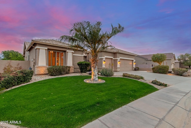 view of front of home with concrete driveway, stucco siding, fence, an attached garage, and a lawn