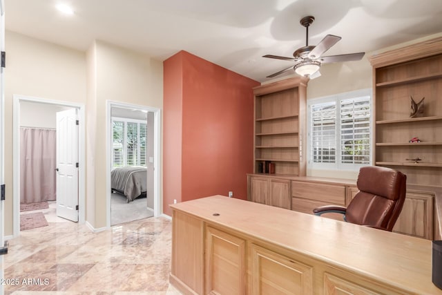 home office featuring baseboards and ceiling fan