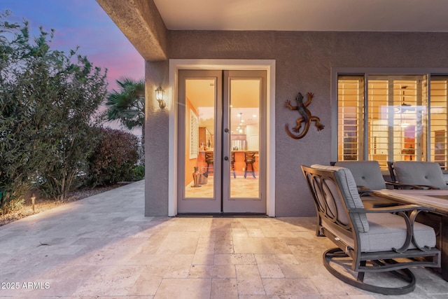 exterior space featuring stucco siding, a patio area, and french doors