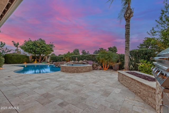 pool with a patio and an in ground hot tub