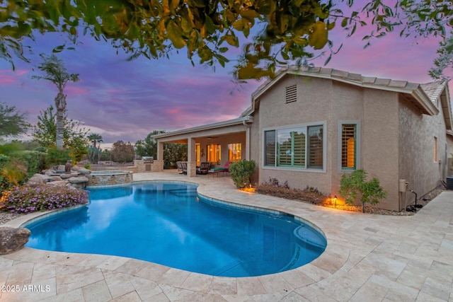 view of swimming pool featuring ceiling fan, a pool with connected hot tub, and a patio