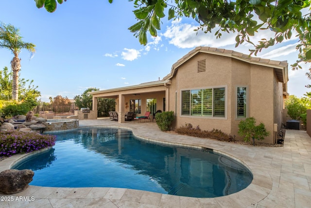 view of swimming pool with fence, central AC unit, a pool with connected hot tub, a ceiling fan, and a patio area