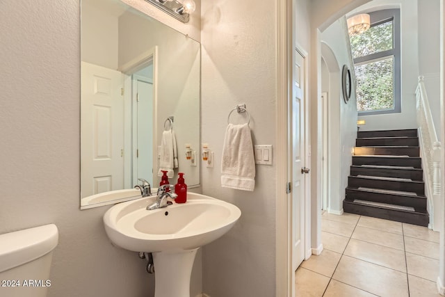 bathroom featuring toilet, tile patterned floors, and sink