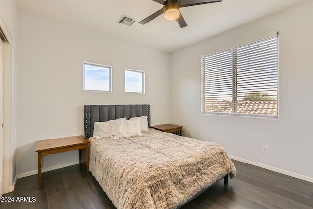 bedroom with multiple windows, dark wood-type flooring, and ceiling fan