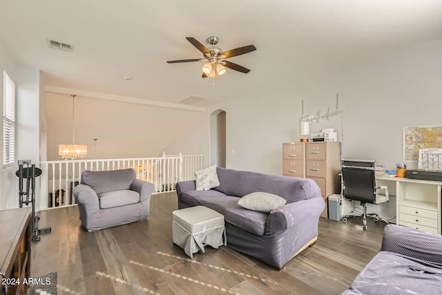 living room featuring ceiling fan with notable chandelier and dark hardwood / wood-style flooring