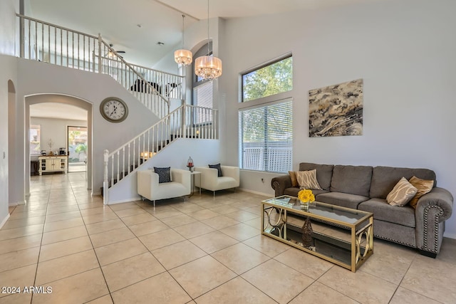 tiled living room with high vaulted ceiling and an inviting chandelier