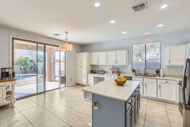 kitchen featuring a center island, white cabinets, pendant lighting, and sink