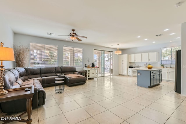 tiled living room with ceiling fan, sink, and a wealth of natural light