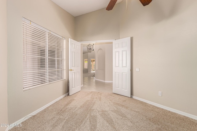 unfurnished bedroom featuring ceiling fan, beam ceiling, light colored carpet, and high vaulted ceiling