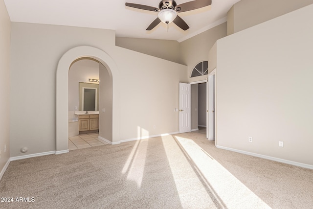 carpeted spare room with ceiling fan, lofted ceiling, and sink