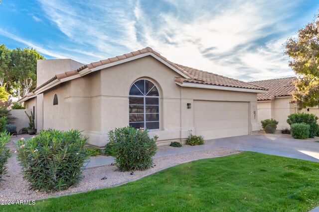 mediterranean / spanish-style house with a garage and a front yard