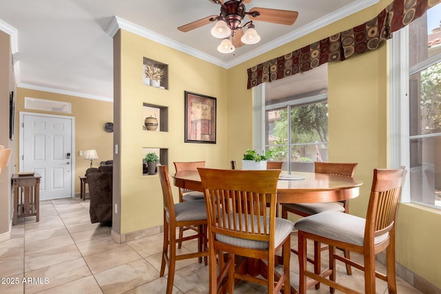 dining space featuring crown molding, light tile patterned flooring, baseboards, and ceiling fan
