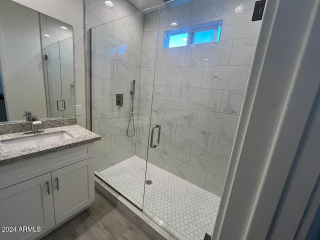 bathroom with vanity and a shower with door