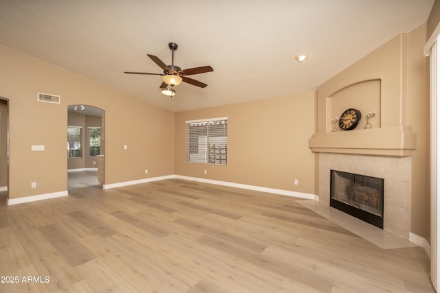 12044 S 45th St, Phoenix, AZ 85044 - unfurnished living room with a fireplace, ceiling fan, light wood-style flooring, arched walkways, and lofted ceiling