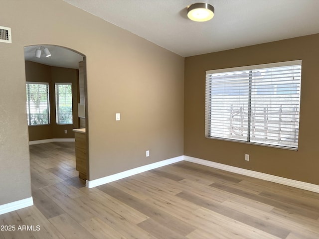 12044 S 45th St, Phoenix, AZ 85044 - spare room featuring arched walkways, light wood finished floors, and baseboards
