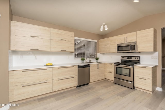12044 S 45th St, Phoenix, AZ 85044 - kitchen featuring light brown cabinetry, appliances with stainless steel finishes, a sink, vaulted ceiling, and light wood-style floors